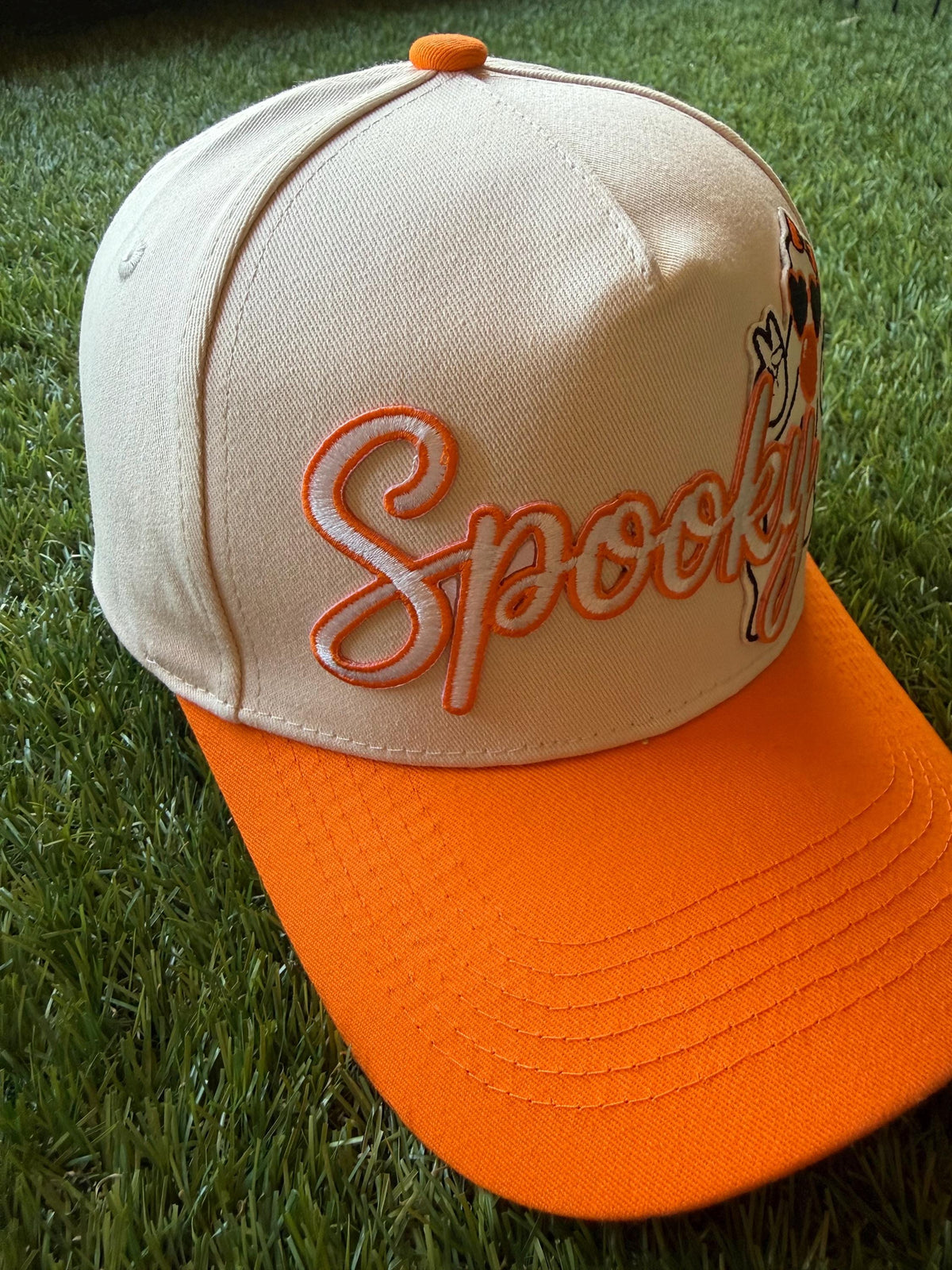 Spooky embroidered patch with ghost blowing a bubble on custom canvas trucker hat with orange brim