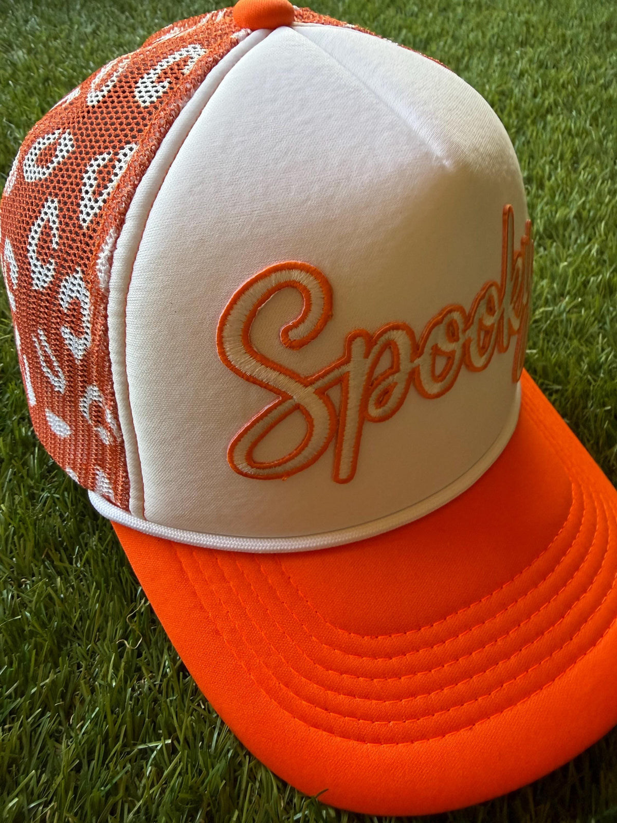 Spooky on a custom trucker hat with a magna pony and orange and white leopard detailed mesh
