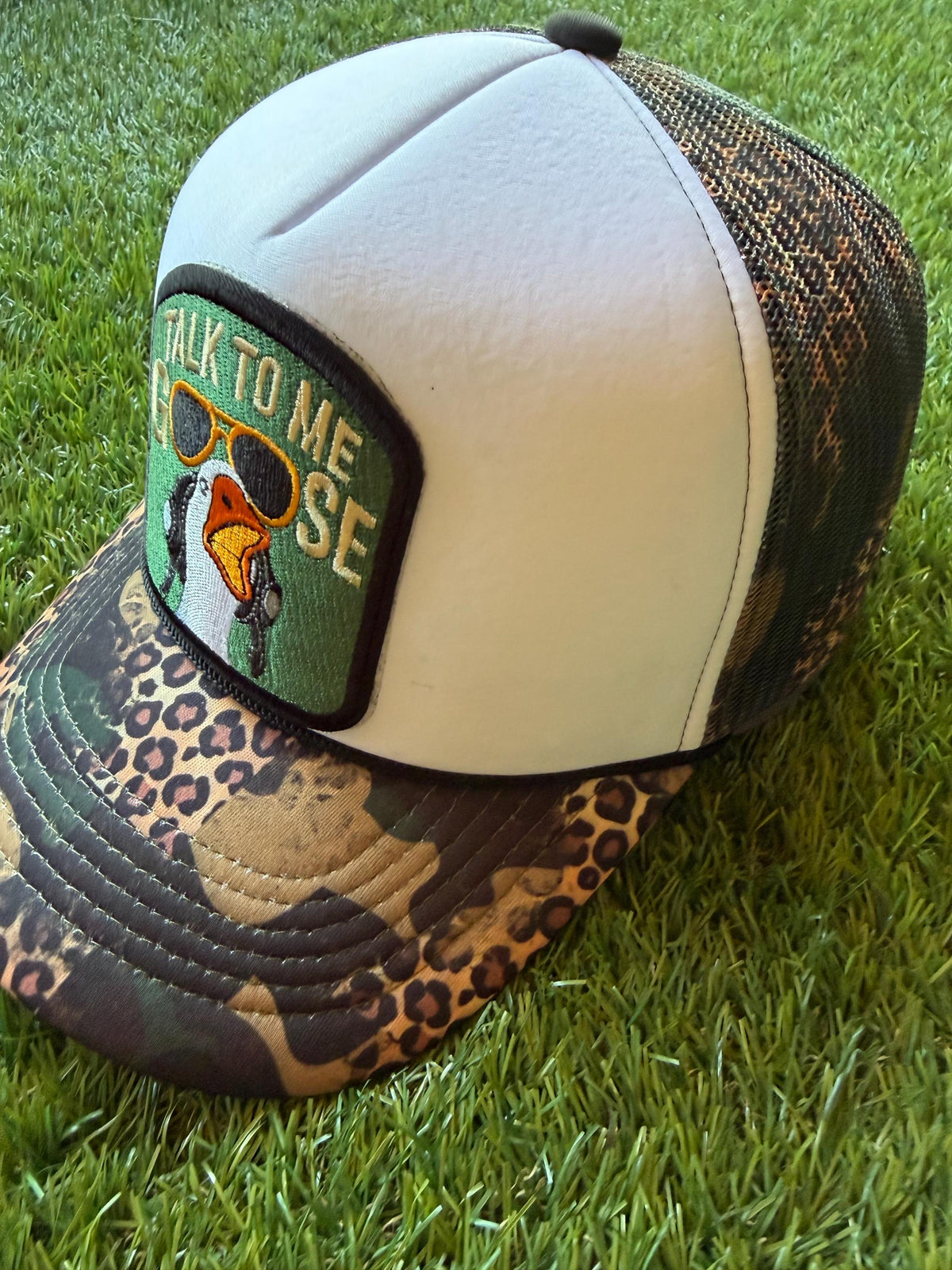 Talk To Me Goose with an image of a goose on a camouflage/leopard print custom canvas trucker hat