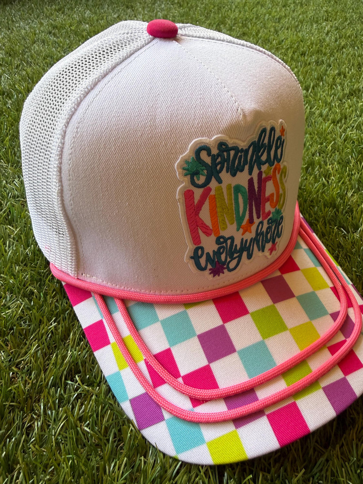 Sprinkle Kindness Everywhere colorful message on a multicolored canvas front with mesh back