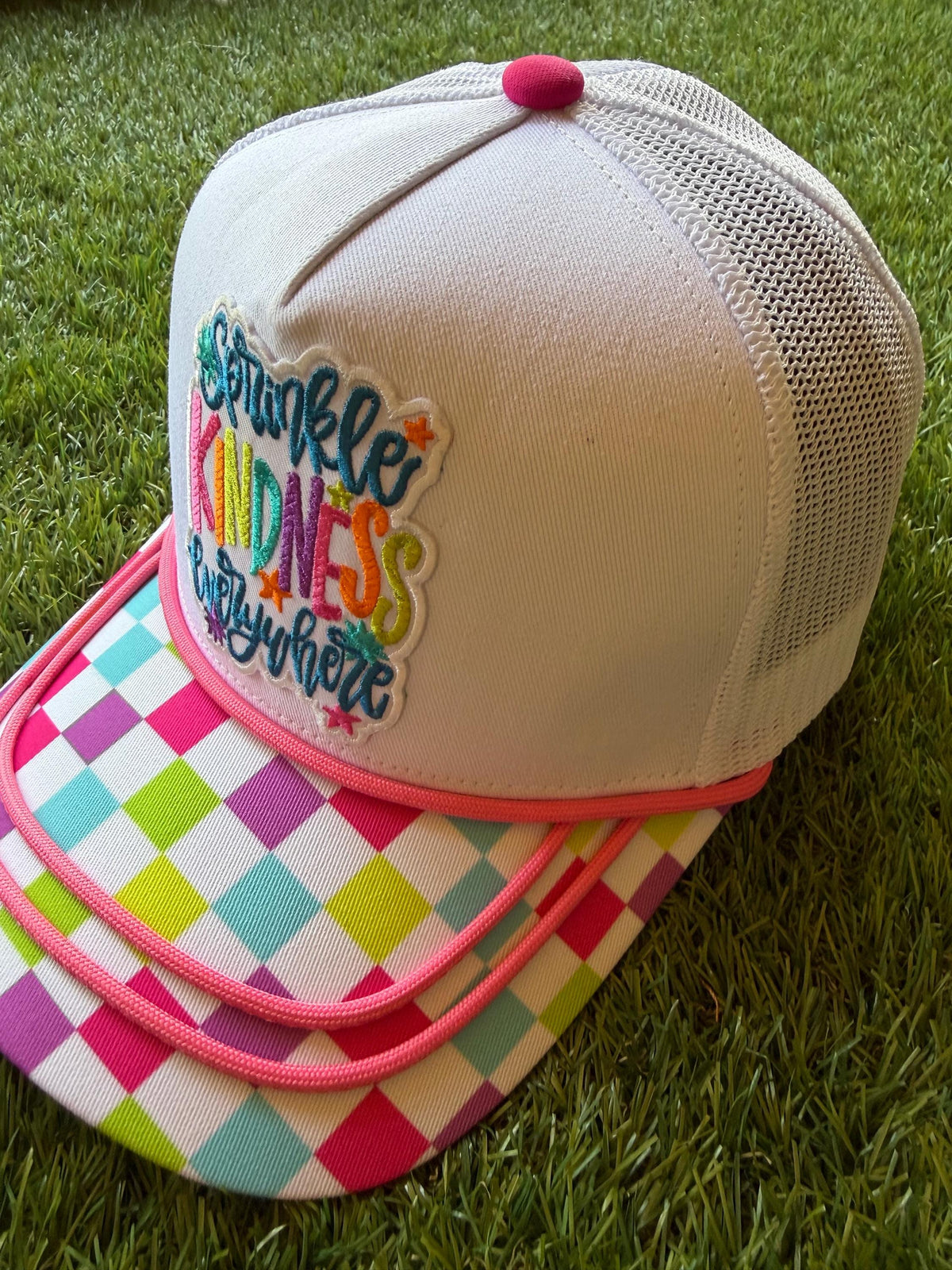 Sprinkle Kindness Everywhere colorful message on a multicolored canvas front with mesh back