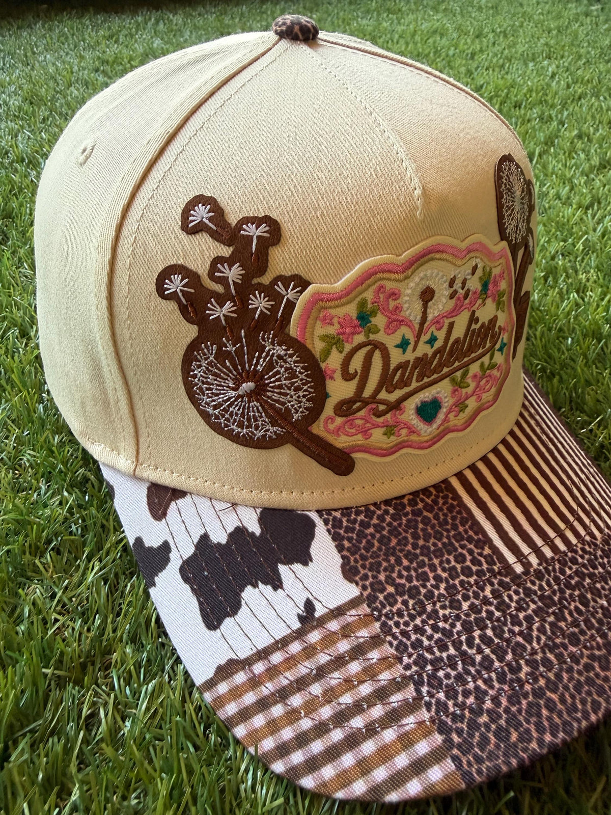 Dandelion embroidered patch with dandelion flowers on a custom canvas trucker hat that has a multi pattern western theme brim