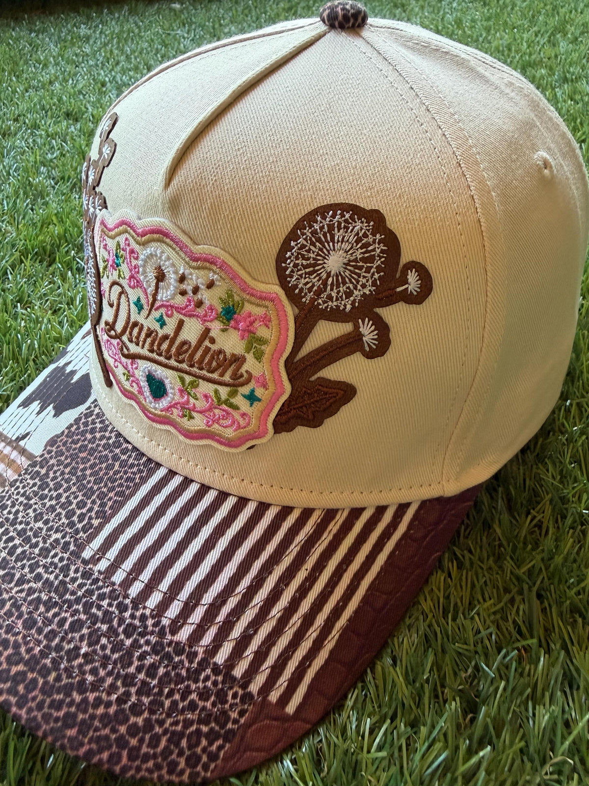 Dandelion embroidered patch with dandelion flowers on a custom canvas trucker hat that has a multi pattern western theme brim