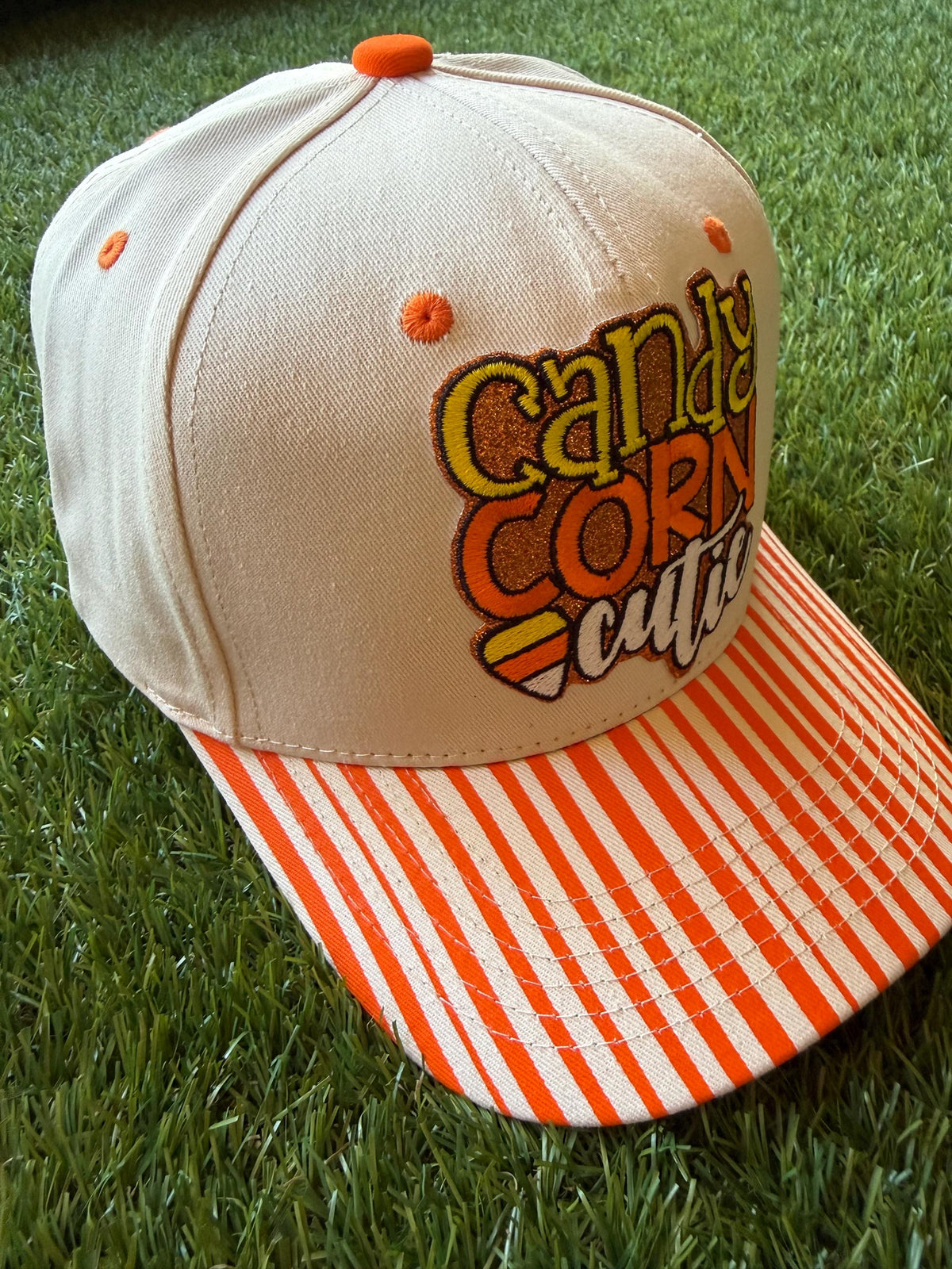 Candy Corn Cutie on a custom canvas trucker hat with orange and beige strips on the brim