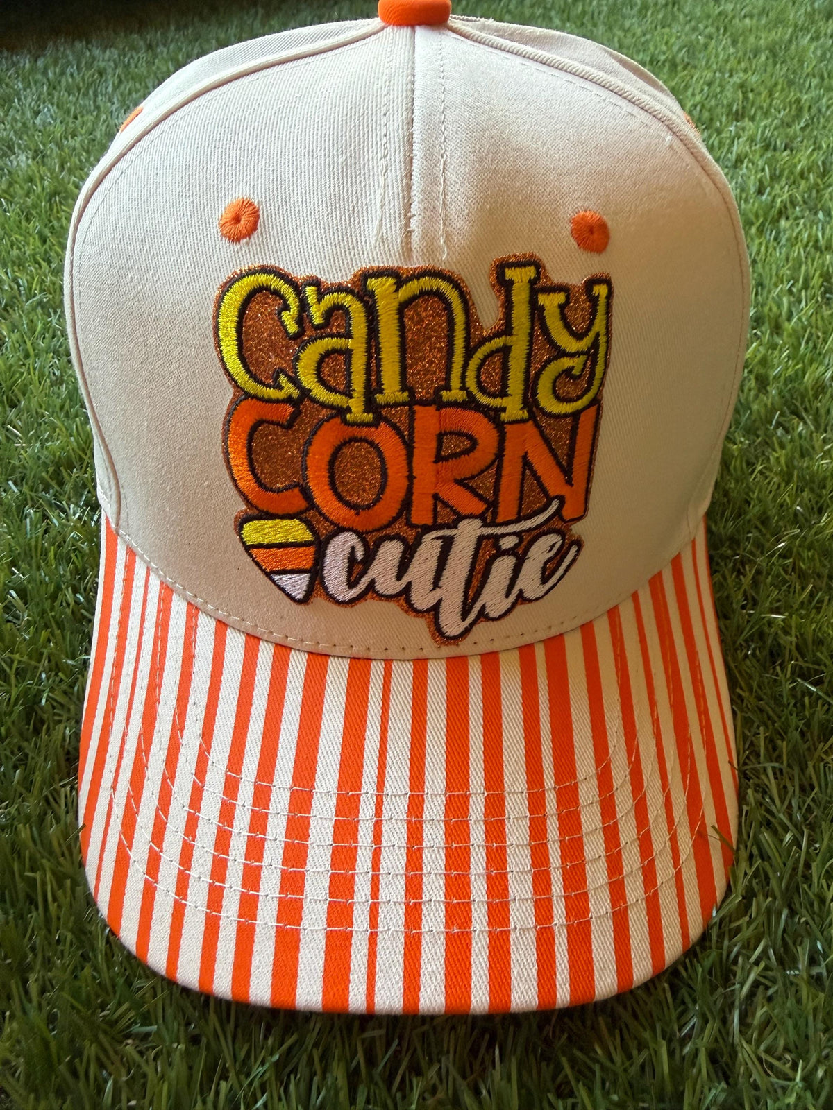 Candy Corn Cutie on a custom canvas trucker hat with orange and beige strips on the brim