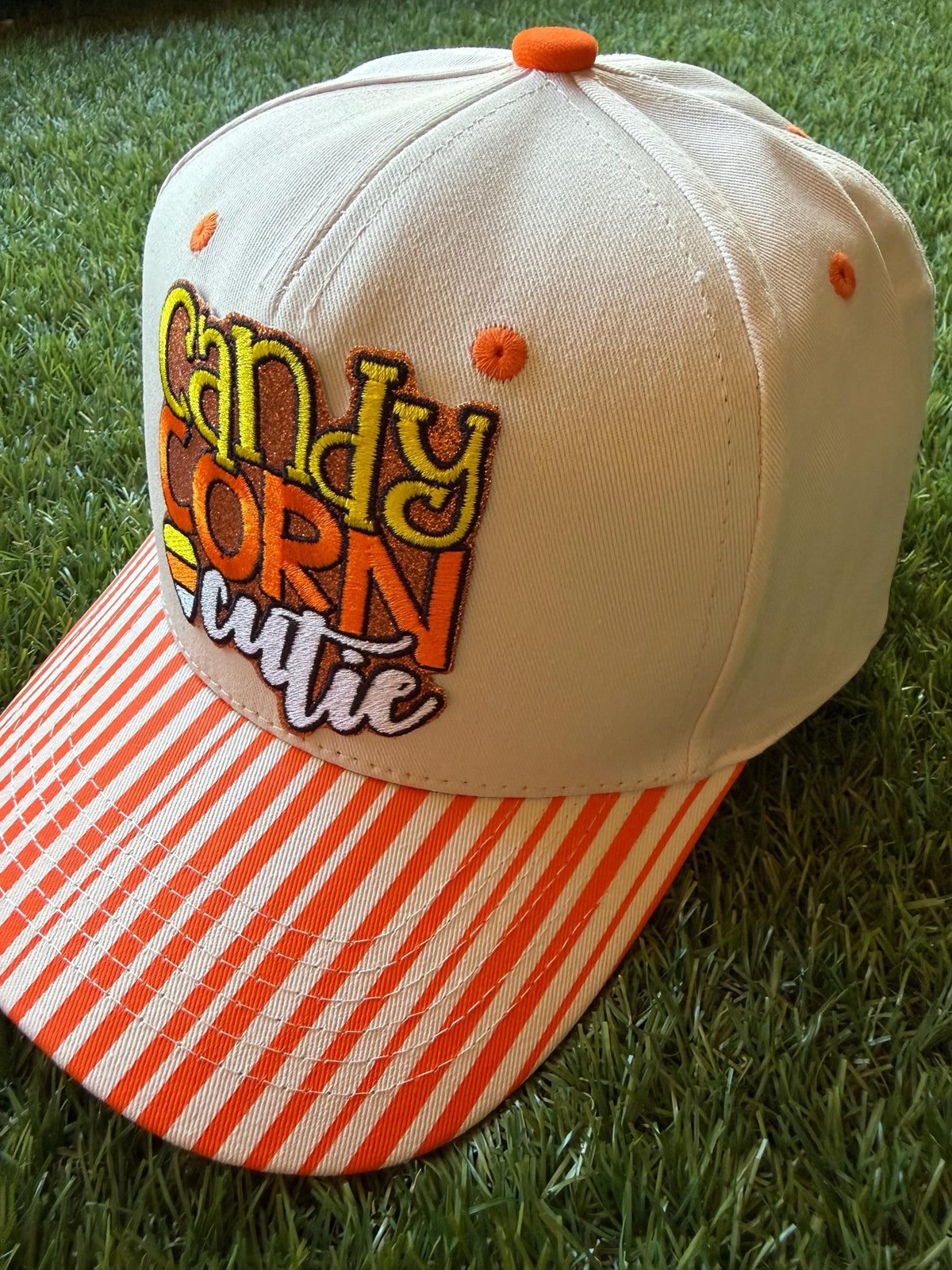 Candy Corn Cutie on a custom canvas trucker hat with orange and beige strips on the brim