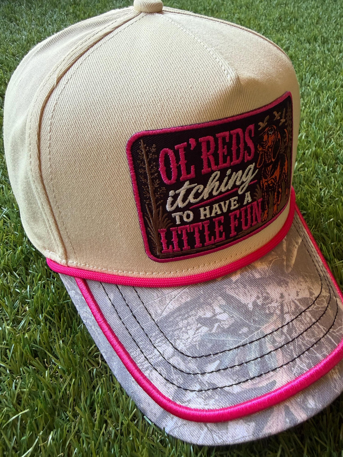 Ol Red’s Itching to Have A Little Fun on a custom canvas trucker with a camouflage brim and hot pink rope detailing