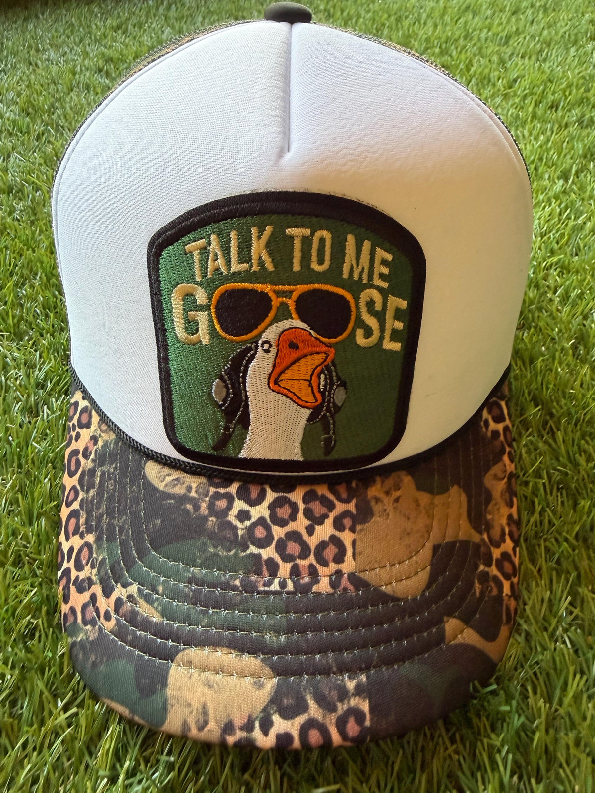 Talk To Me Goose with an image of a goose on a camouflage/leopard print custom canvas trucker hat