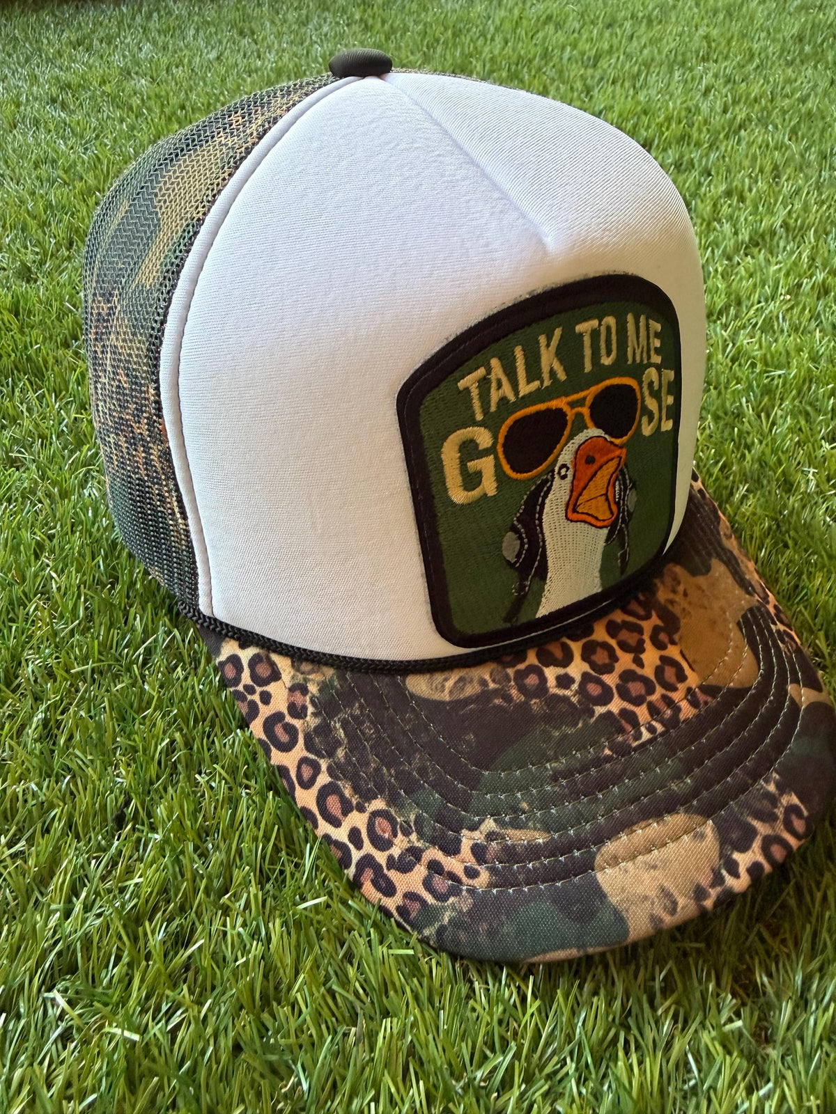 Talk To Me Goose with an image of a goose on a camouflage/leopard print custom canvas trucker hat