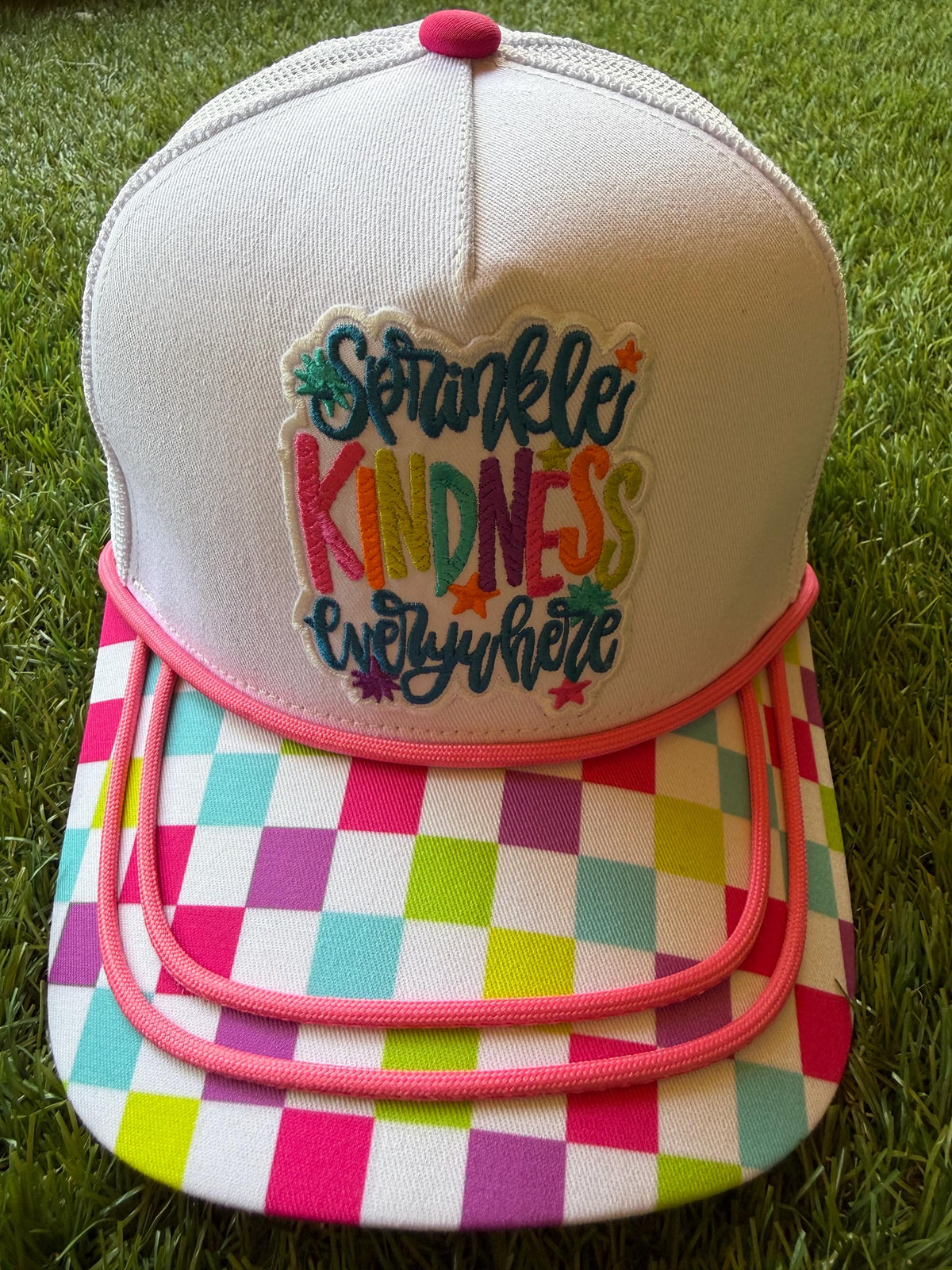 Sprinkle Kindness Everywhere colorful message on a multicolored canvas front with mesh back