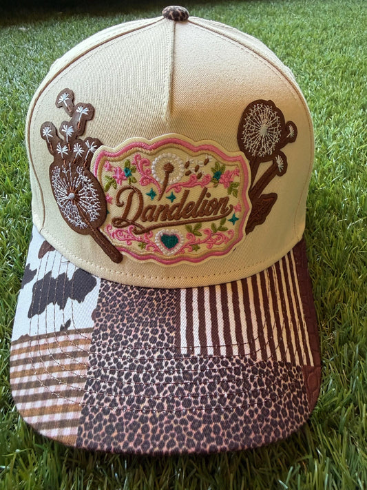 Dandelion embroidered patch with dandelion flowers on a custom canvas trucker hat that has a multi pattern western theme brim