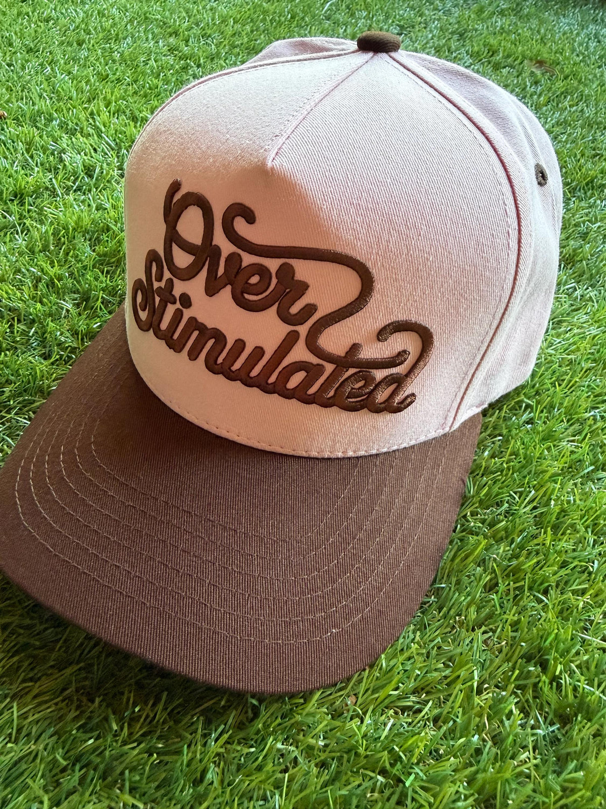 Over Stimulated embroidered word patch on a custom canvas trucker hat
