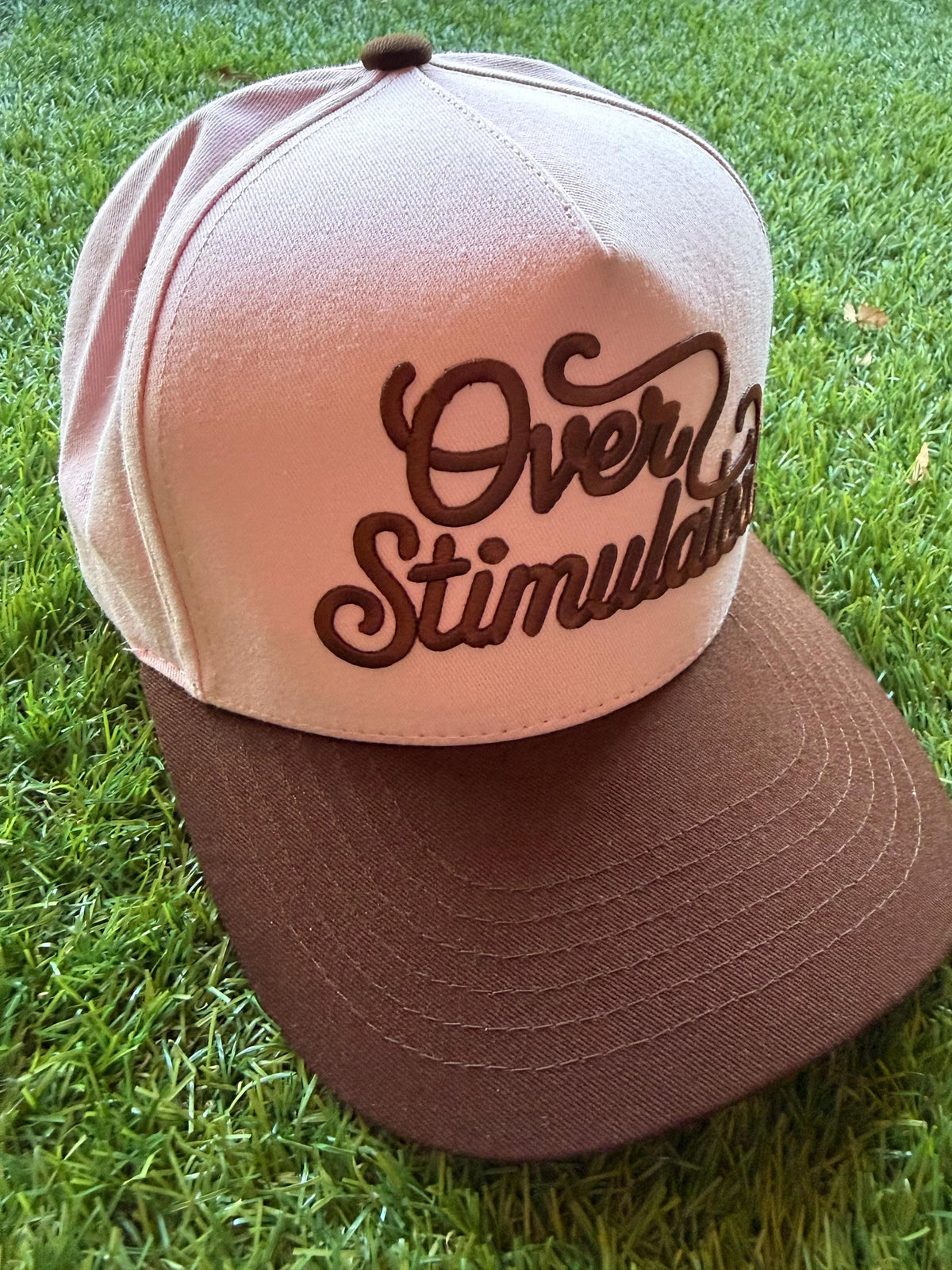 Over Stimulated embroidered word patch on a custom canvas trucker hat