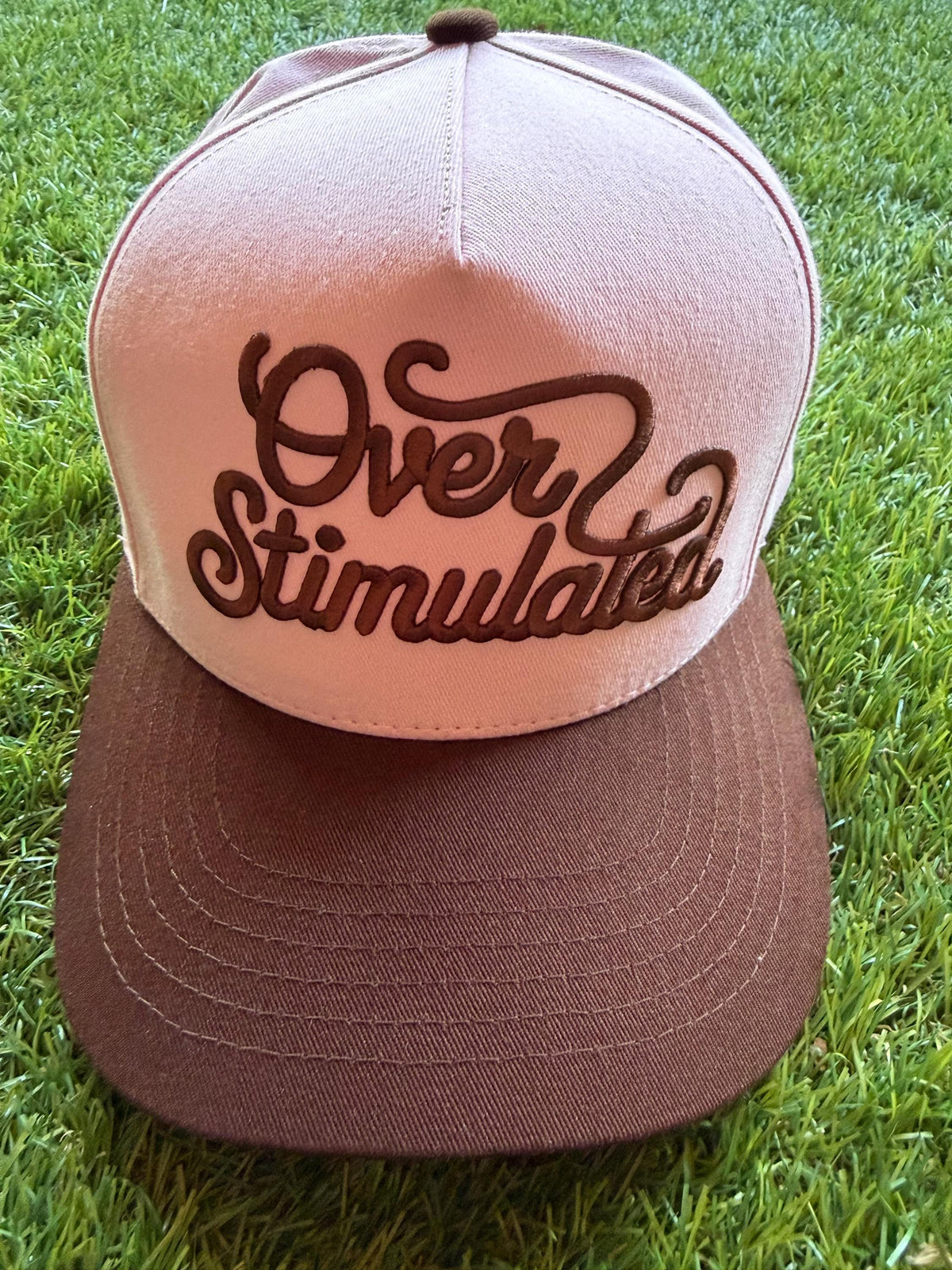Over Stimulated embroidered word patch on a custom canvas trucker hat