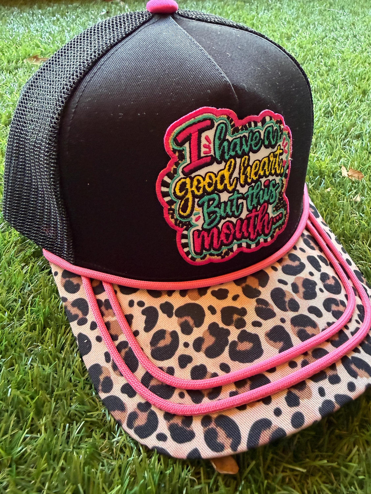 I Have A Good Heart But This Mouth embroidered patch on a custom canvas mesh trucker hat combo with a leopard brim and hot pink detailing